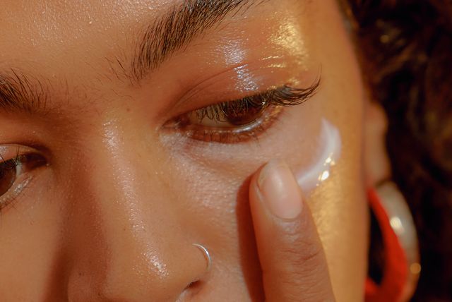 closeup of a young confident woman applying eye cream