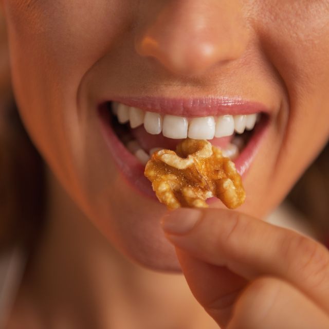 closeup on young housewife eating walnuts