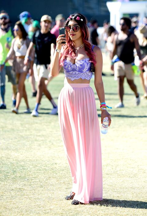 a coachella 2016 attendee in a purple corset and pink maxi skirt