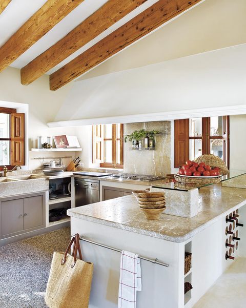 cocina de estilo rústico con techo abuhardillado y vigas de madera