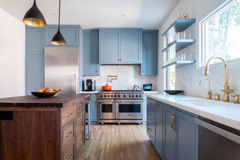 cocina azul con isla central de madera y estilo retro