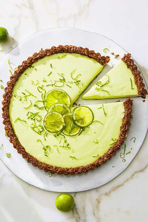 a slice of cocoa nutty lime tart on a white background