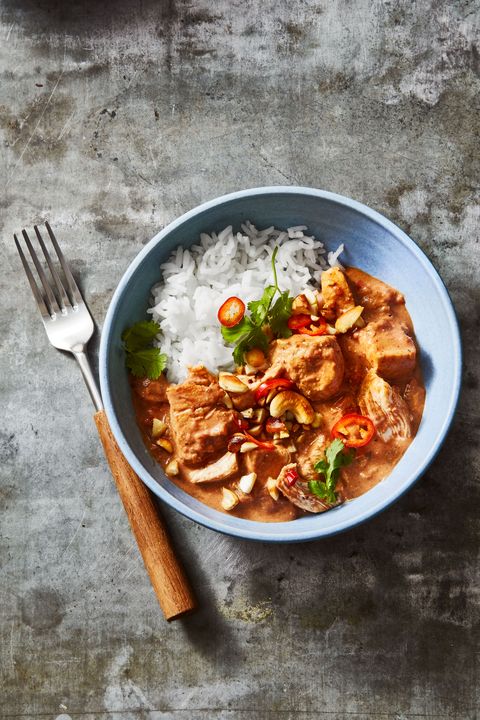 coconut curry chicken in a blue bowl with a fork