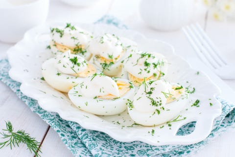 Cold snack of boiled eggs with mayonnaise on a white plate, horizontal cold snack of boiled eggs with mayonnaise on a white plate, horizontal