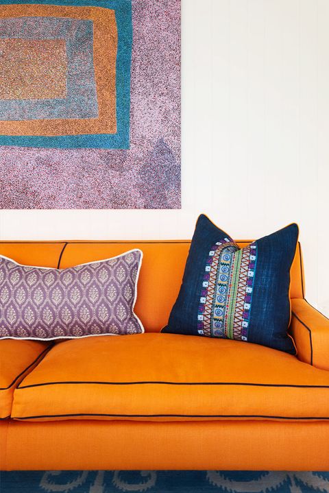 living room with orange sofa and purple art