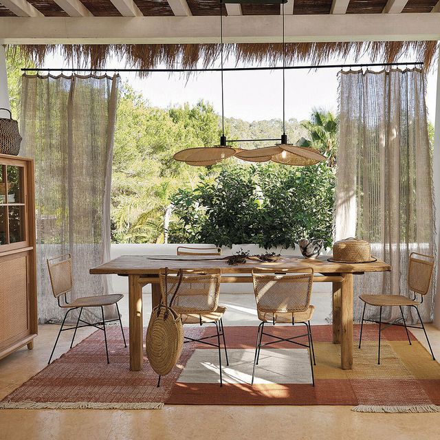 comedor exterior de madera y cortinas de lino