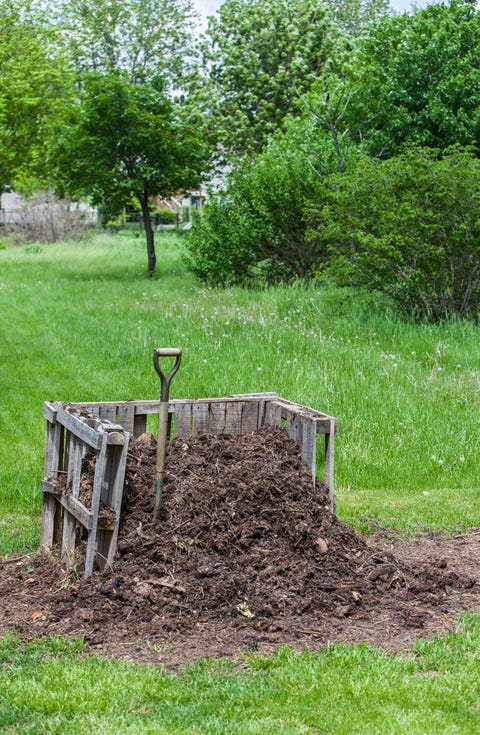 a pile of compost in a homemade bin in the suburban backyard in il