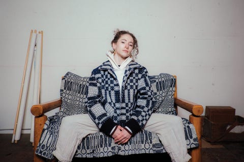 Person sitting on sofa wearing slow process jacket