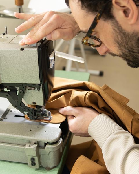 Man sewing a jacket with a sewing machine