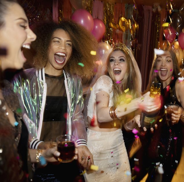Confetti falling over laughing bachelorette and friends in nightclub