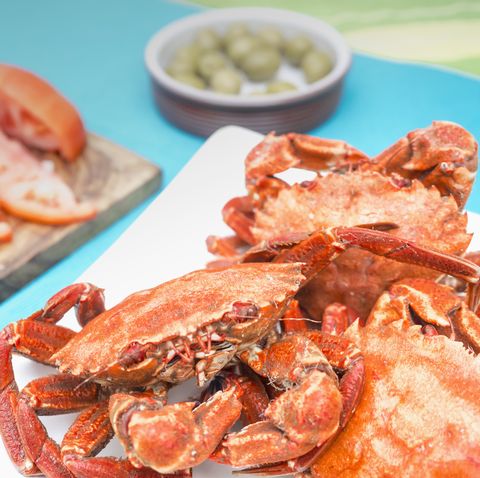 Cooked velvet crabs served with tomatoes and olive