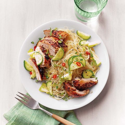 cool chicken and noodle salad on a white plate on a light grey background