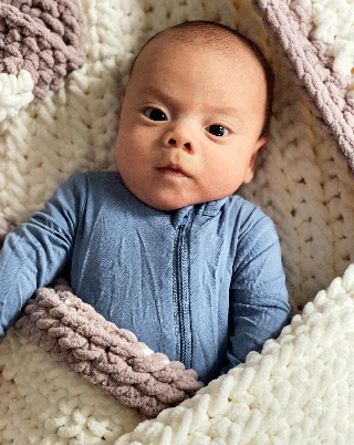 baby wrapped in handmade crochet blanket