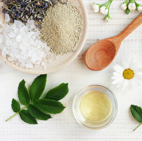 Cosmetic oil, clay, sea salt, herbs, plant leaves. Facial treatment preparation background.