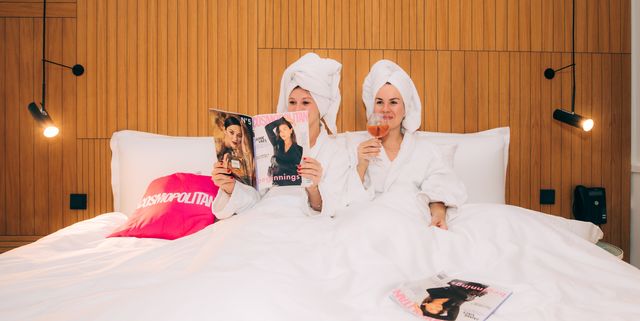 twee vrouwen in een bed met een cosmopolitan blad