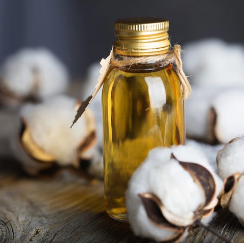 Cottonseed oil in a glass bottle on a wooden surface. Closeup What Types of Food To Eat and Avoiding