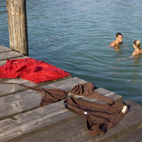 a couple bathing naked in a lake