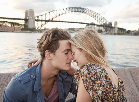 couple embracing in front of sydney harbour bridge
