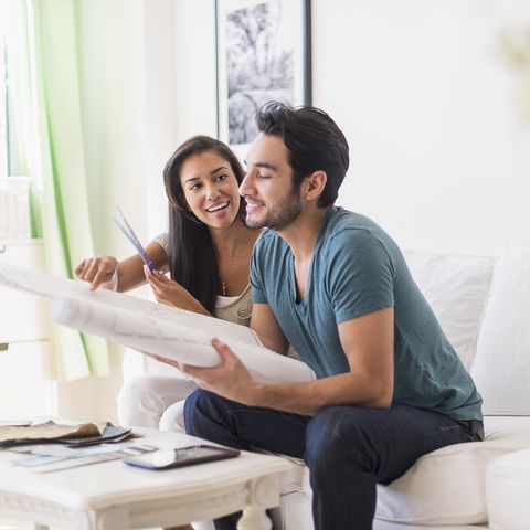 couple examining blueprints in living room