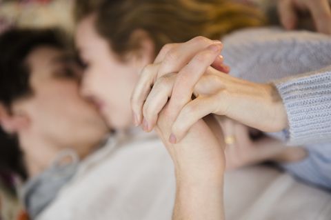 couple holding hands while kissing