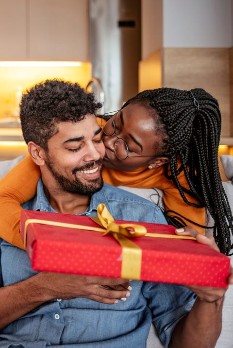 A Black couple giving each other a red wrapped gift a black couple giving each other a red wrapped gift