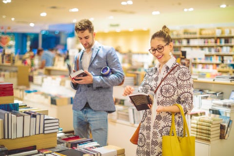 Couple is selecting new books in the bookstore Couple is selecting new books in the bookstore