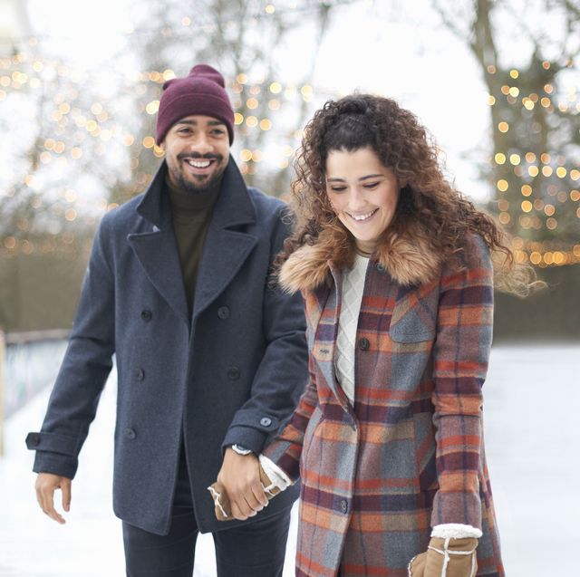 couple on ice rink holding hands smiling