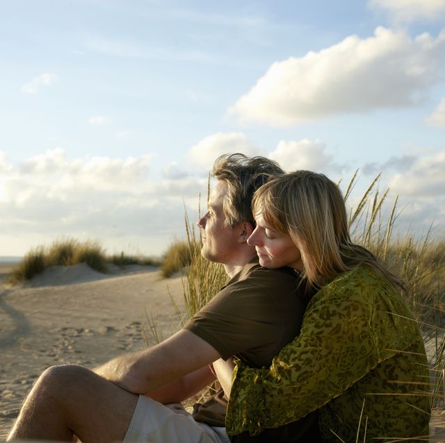 couple sitting embracing on beach