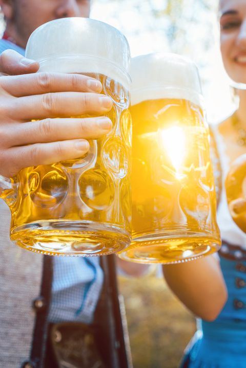 couple toasting beer glasses while standing outdoors