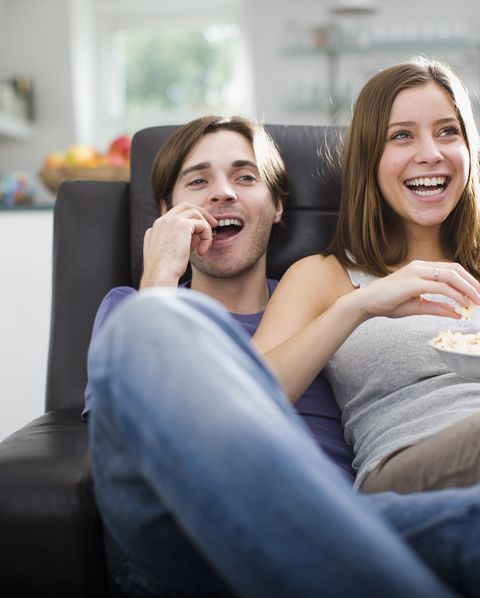 couple watching television and eating popcorn