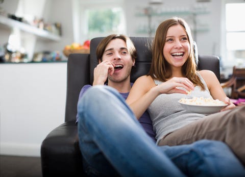 couple watching television and eating popcorn