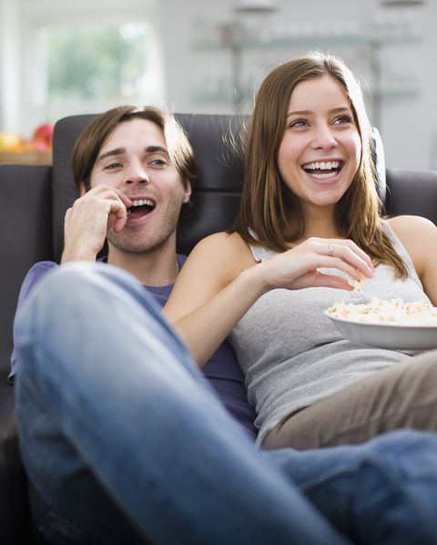 couple watching television and eating popcorn