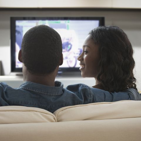 couple watching television on sofa