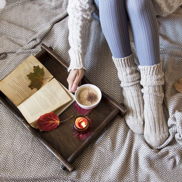 gezellig herfstplaatje met wollen sokken, koffie en een kaars en een zachte deken