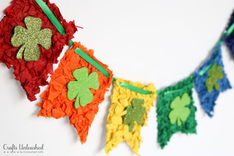 rainbow banner made out of tissue paper with glittery shamrocks stuck in the middle of each individual pennant