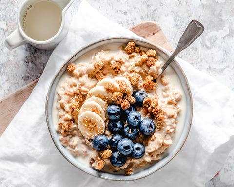 creamy oatmeal bowl with banana, blueberries, mulberries and sesame seeds