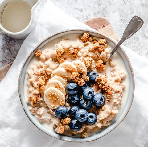 creamy oatmeal bowl with banana, blueberries, mulberries and sesame seeds