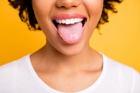 cropped close up photo beautiful amazing she her dark skin lady beaming whitening toothy smile tongue out perfect mouth wear casual white t shirt isolated yellow bright vibrant background