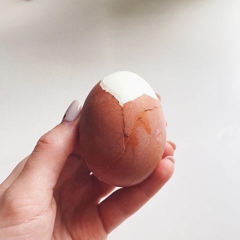 cropped hand holding boiled egg