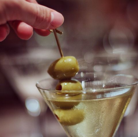 Cropped Hand Holding Green Olives