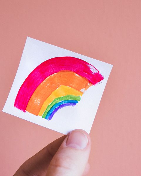 Cropped Hand Holding Paper With Colorful Paint Against Colored Background