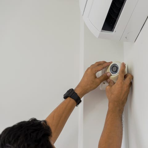 Hombre mano recortada instalación de circuito cerrado de televisión en la pared en casa Mano recortada instalando circuito cerrado de televisión en la pared en casa