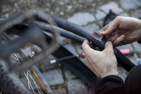 cropped image of man repairing bicycle tire tube on royalty free image 536943697 1548428970