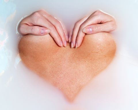 cropped image of woman with hands on chest making heart shape in water