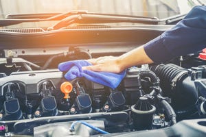 Cropped Of Mechanic Cleaning Car Engine