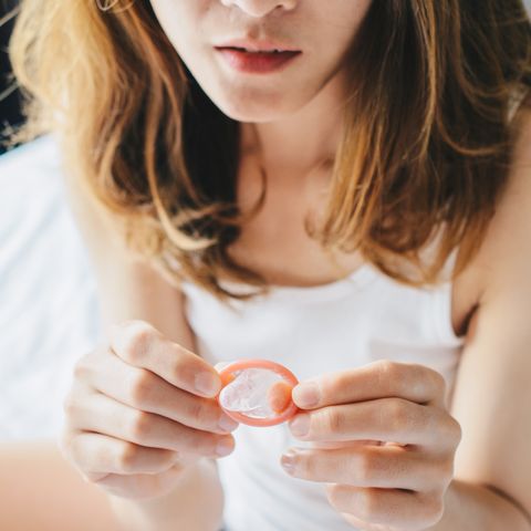 cropped shot view of woman holding a small condom on her hand before using it with her partner