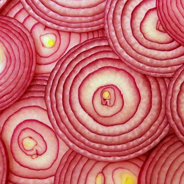 cross sections of a red onion with slices stacked in random fashion
