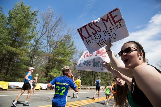 varias aficionadas enseñan pancartas de ánimo a los corredores del maratón de boston