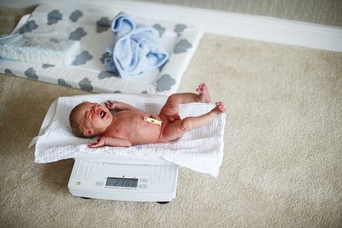 recién nacido llorando en una báscula para controlar su peso