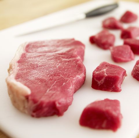 cubed raw steak on cutting board